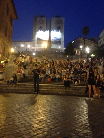 Spanish steps occupied by a young, frenzied crowd after dinner and drinks. Live music completes the scene. 